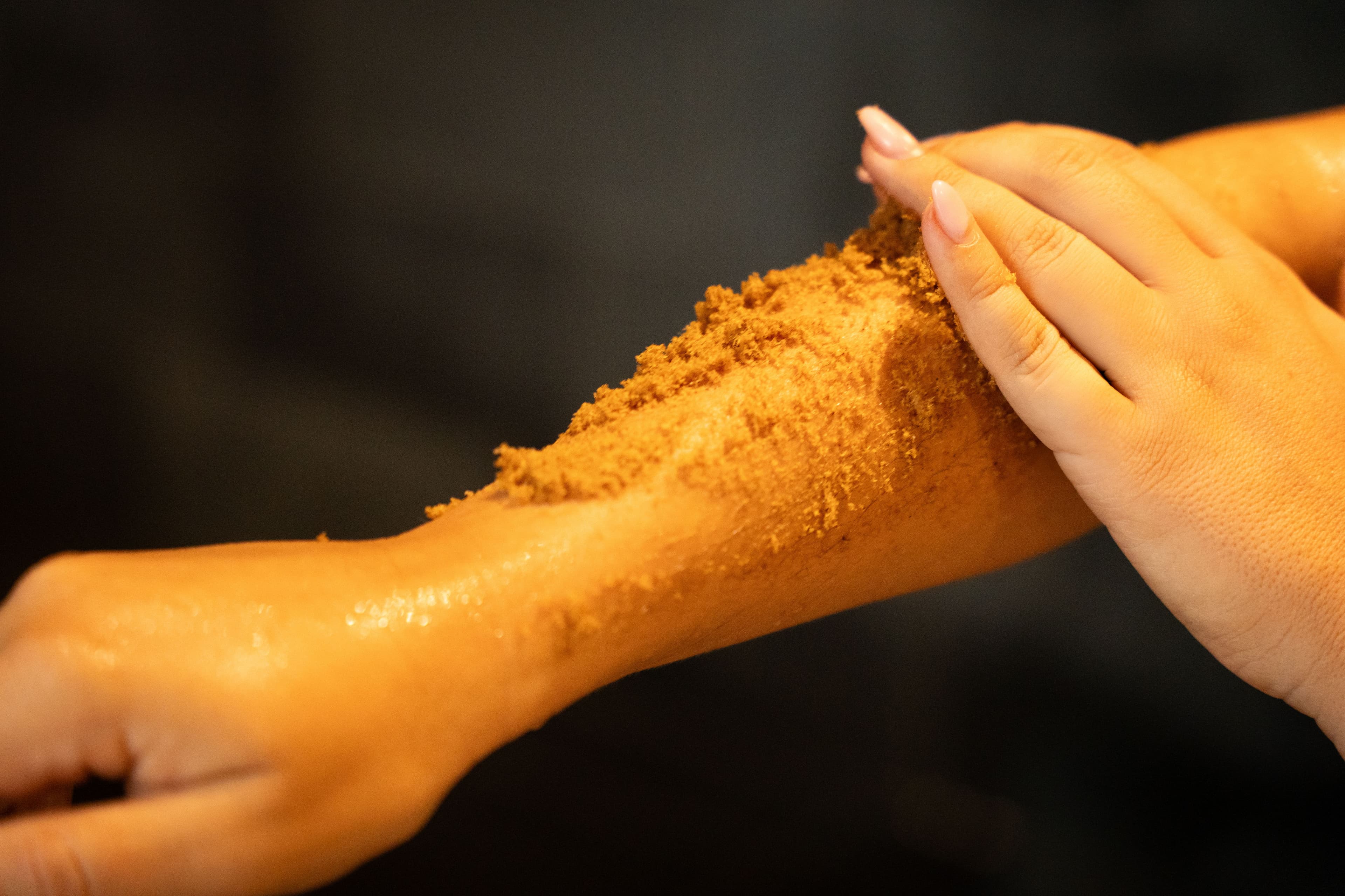 Handmassage met natuurlijke scrub in een serene wellnessomgeving bij Thermen Binnenmaas