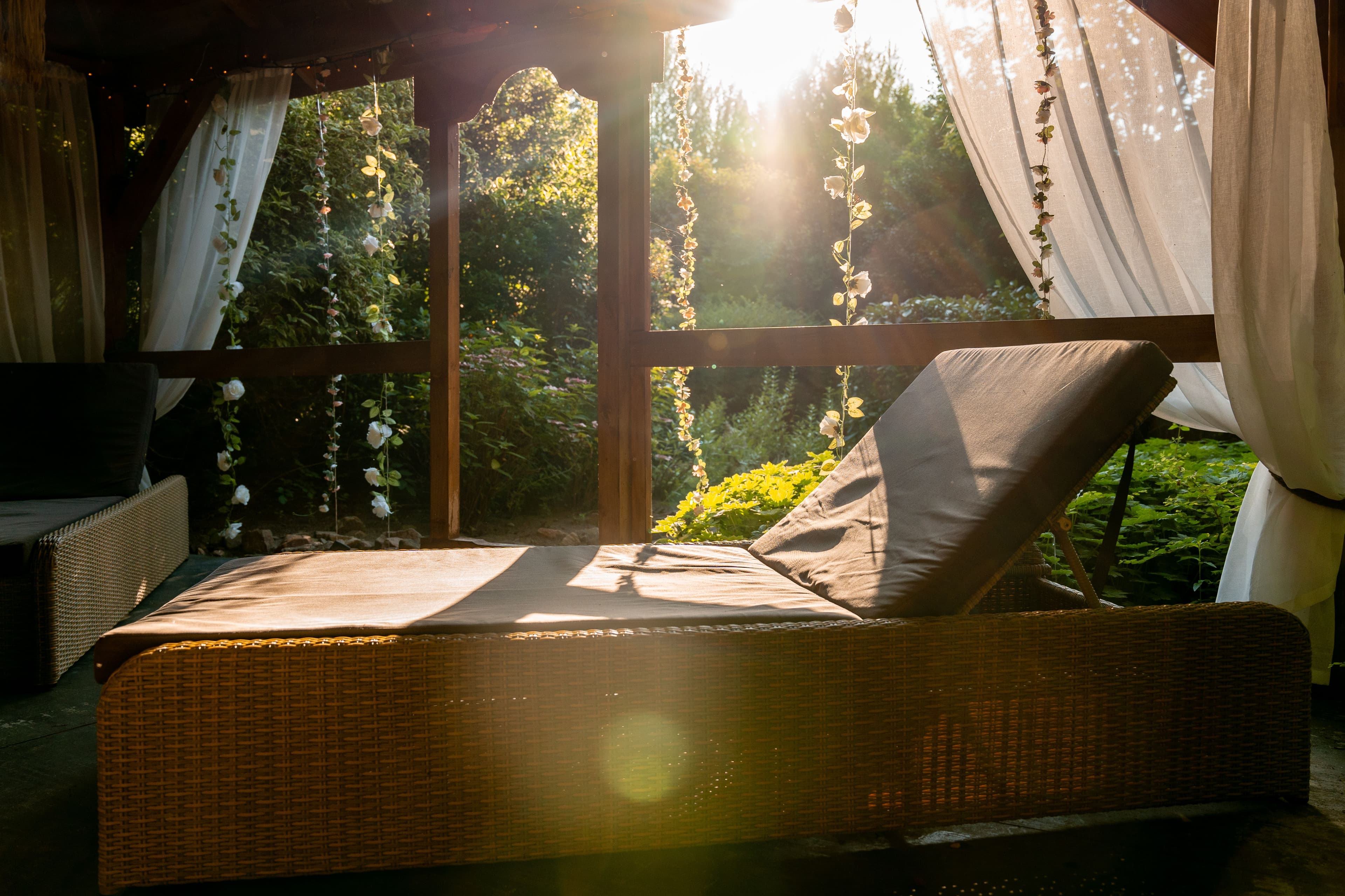 Zonovergoten ligbed in bloeiende tuin