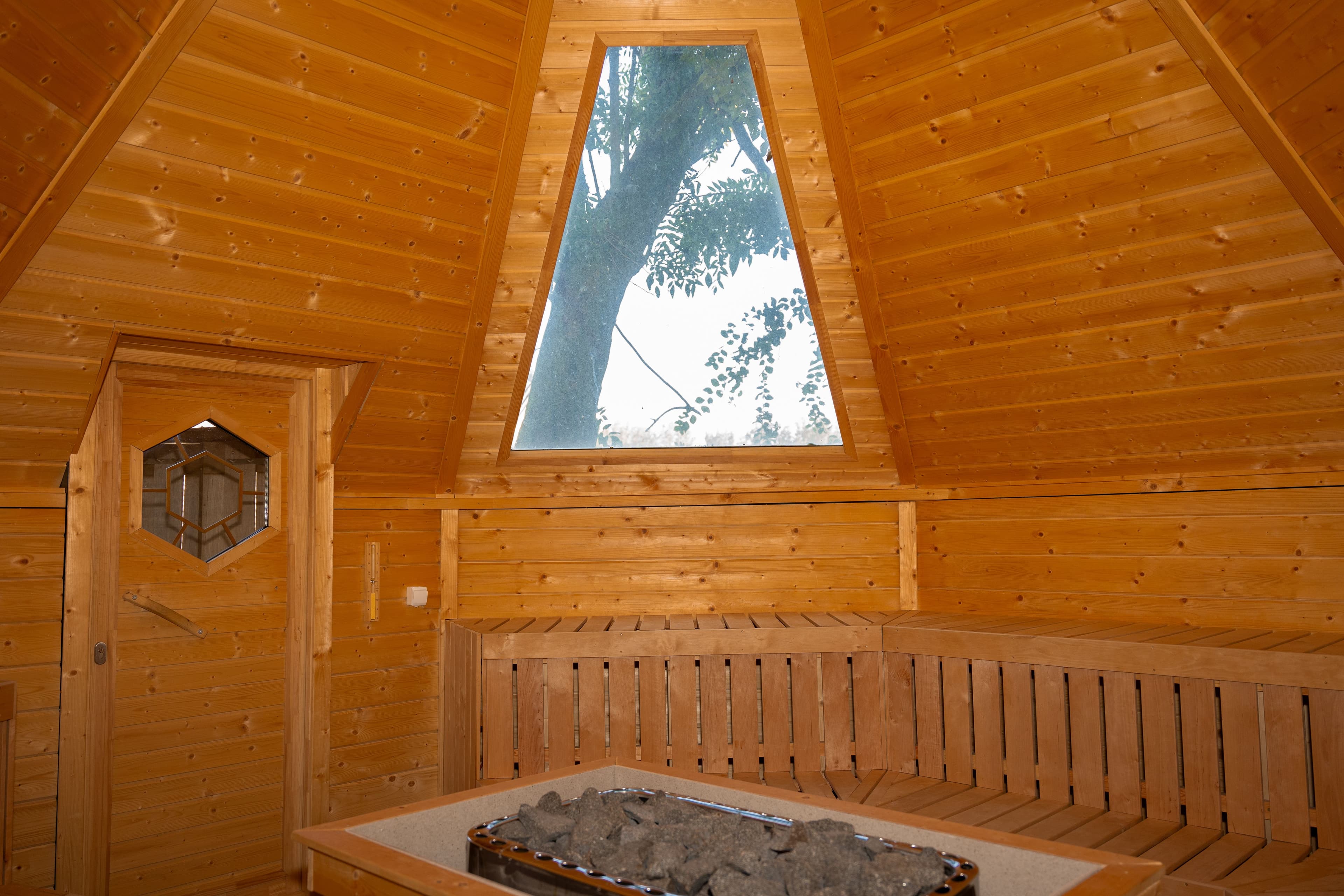 Houten sauna met centraal geplaatste oven voor optimale warmteverspreiding